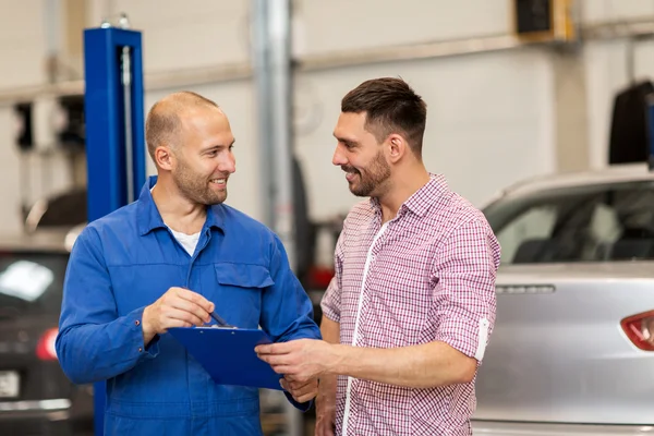 Meccanico con appunti e uomo in officina — Foto Stock