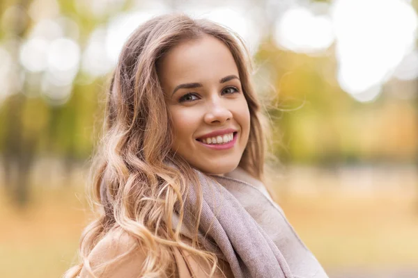 Красивая счастливая молодая женщина улыбается в осеннем парке — стоковое фото