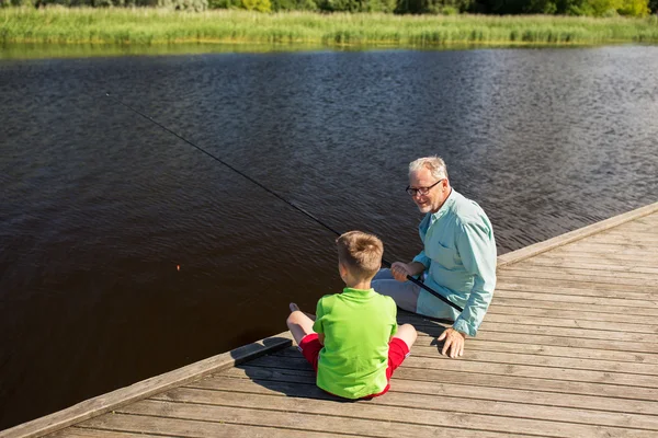 Avô e neto pesca no cais do rio — Fotografia de Stock
