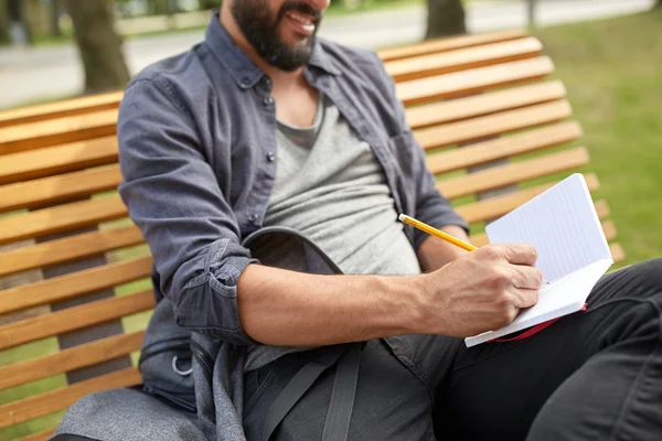 Nahaufnahme eines Mannes, der auf der Stadtstraße an ein Notizbuch schreibt — Stockfoto