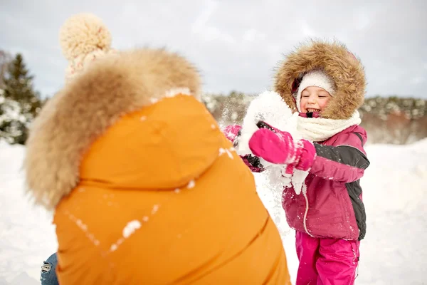 Happy family in winter clothes playing with snow — Stock Photo, Image