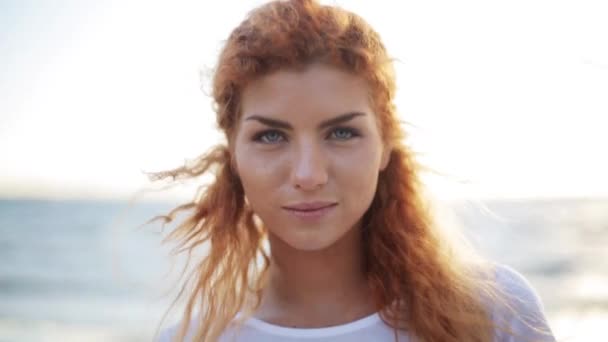 Счастливая молодая рыжая женщина на пляже — стоковое видео
