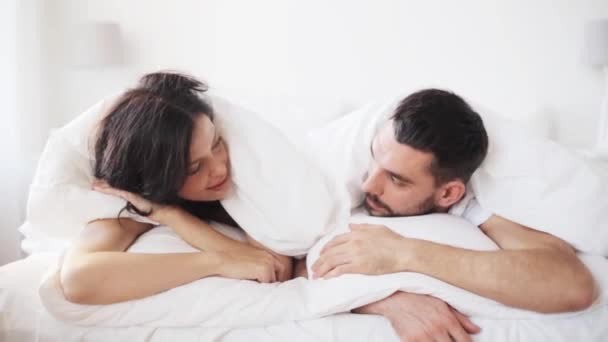 Feliz pareja acostada en la cama en casa — Vídeos de Stock