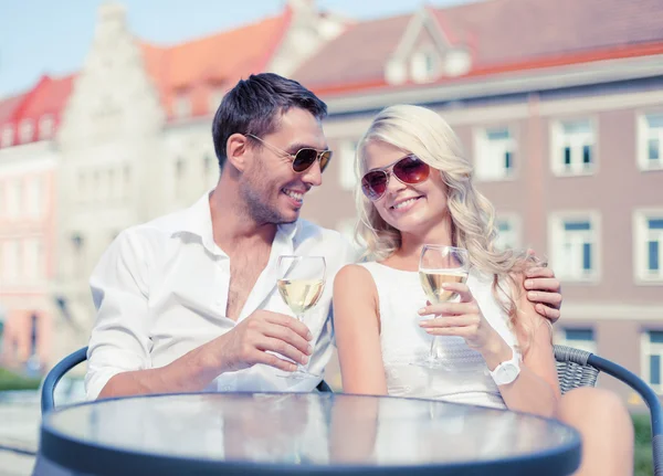 Pareja sonriente en gafas de sol bebiendo vino en la cafetería —  Fotos de Stock