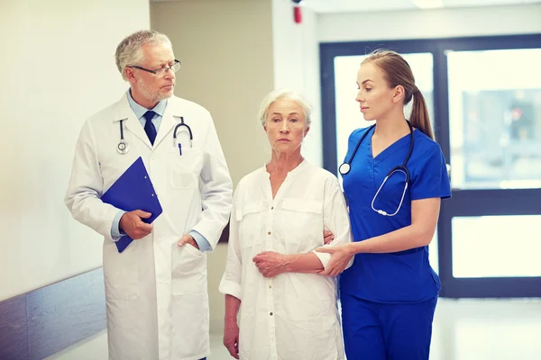 Dokters en senior patiënt vrouw in ziekenhuis — Stockfoto