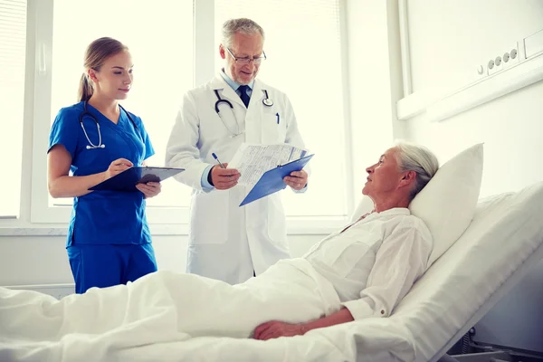 Arzt und Krankenschwester besuchen Seniorin im Krankenhaus — Stockfoto