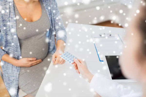 Nahaufnahme eines Arztes, der schwangeren Frau Pillen verabreicht — Stockfoto