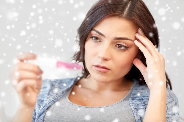 Sad woman looking at home pregnancy test — Stockfoto