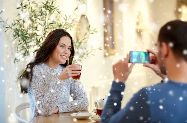 Mann fotografiert Frau mit Smartphone im Café — Stockfoto