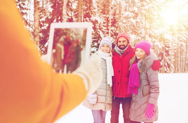 Smiling friends with tablet pc in winter forest — Stock Photo, Image