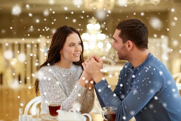 Coppia felice con tè che si tiene per mano al ristorante — Foto Stock