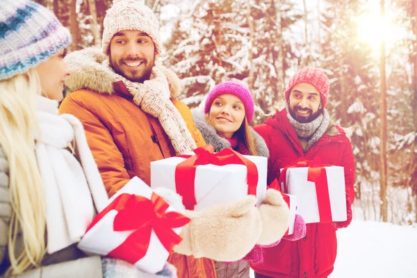 Amigos felices con cajas de regalo en el bosque de invierno —  Fotos de Stock