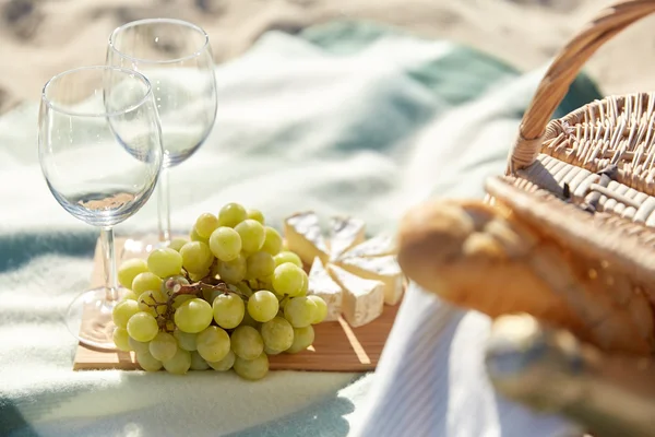 酒杯与食物在海滩上野餐 — 图库照片