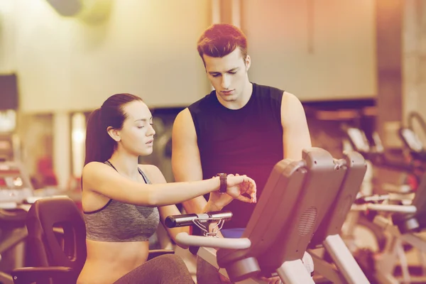 Femme avec entraîneur sur vélo d'appartement dans la salle de gym — Photo