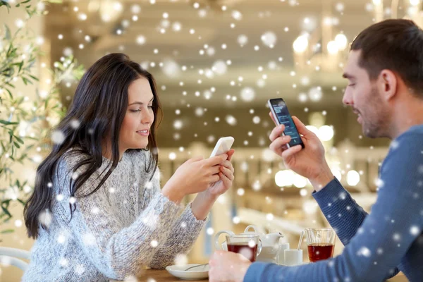 Šťastný pár s chytrými telefony pití čaje v kavárně — Stock fotografie