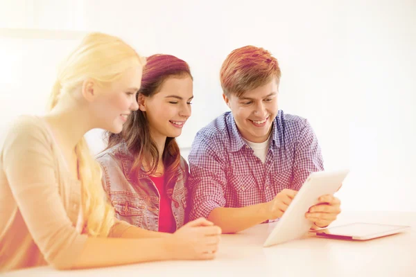 Usmívající se studenti s počítačem tablet pc ve škole — Stock fotografie