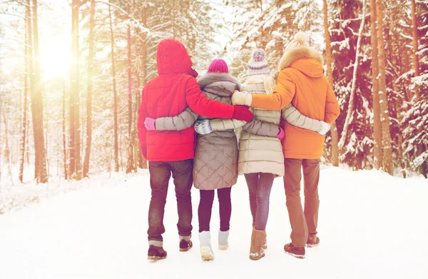 Group of happy men and women in winter forest — Stock Photo, Image