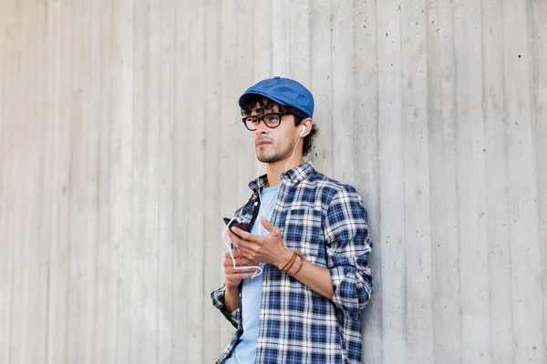 Homem com fones de ouvido e smartphone ouvindo música — Fotografia de Stock