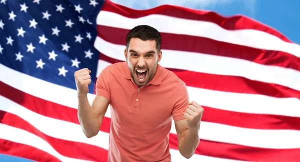 アメリカ国旗の上の拳を見せて怒っている人 — ストック写真