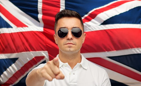 Man in shades pointing finger over brittish flag — Stockfoto