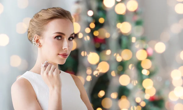 Mujer con joyas de diamantes sobre luces de Navidad — Foto de Stock