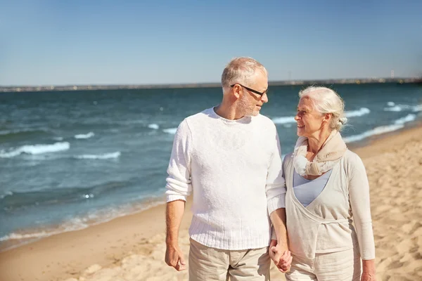 Gelukkige senior paar wandelen langs strand van de zomer — Stockfoto