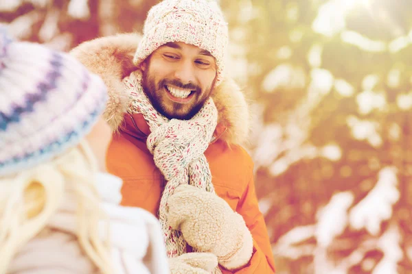 Happy friends or couple in winter forest — Stock Photo, Image