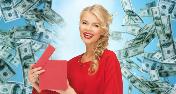 Gelukkige vrouw in het rood met geschenken over geld regen — Stockfoto