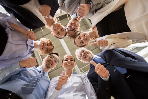 Business people snowing thumbs up at office — Stockfoto