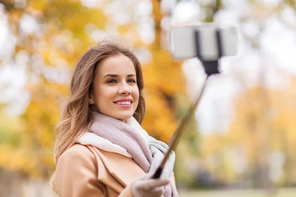 Kvinnan tar selfie av smartphone i höst park — Stockfoto