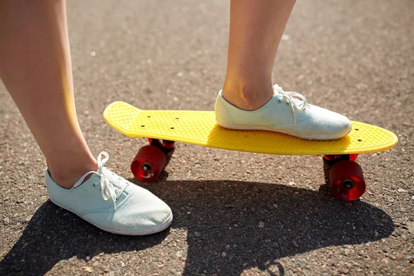 Primo piano di piedi femminili cavalcando skateboard corto — Foto Stock