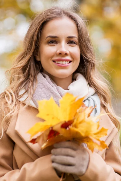 Mooie vrouw met esdoorn bladeren in de herfst park — Stockfoto