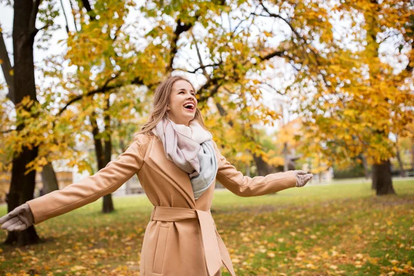 Schöne glückliche junge Frau, die im herbstlichen Park spaziert — Stockfoto