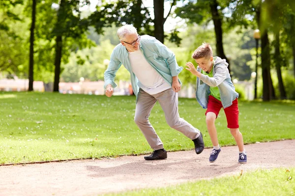 Abuelo y nieto corriendo en el parque de verano — Foto de Stock