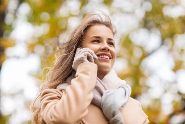 Frau ruft im Herbstpark mit Smartphone an — Stockfoto
