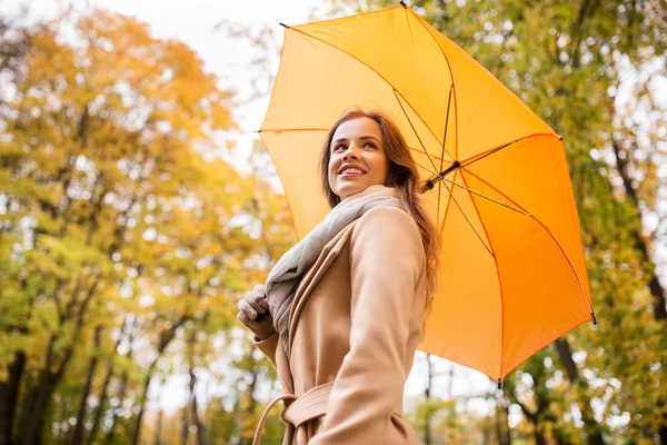 快乐的女人带着雨伞在秋天的公园里散步 — 图库照片