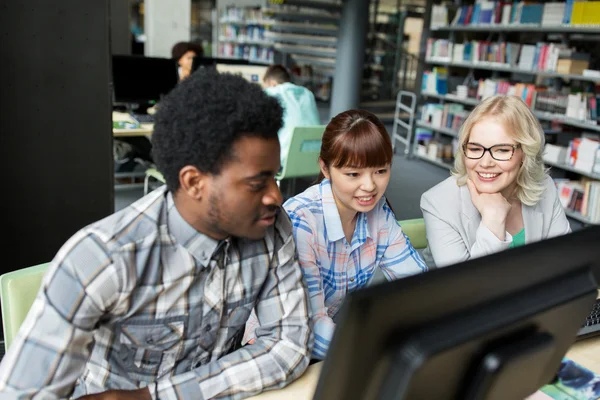 Estudantes internacionais com computadores na biblioteca — Fotografia de Stock