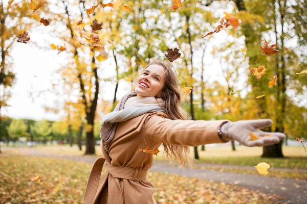 Mulher feliz se divertindo com folhas no parque de outono — Fotografia de Stock