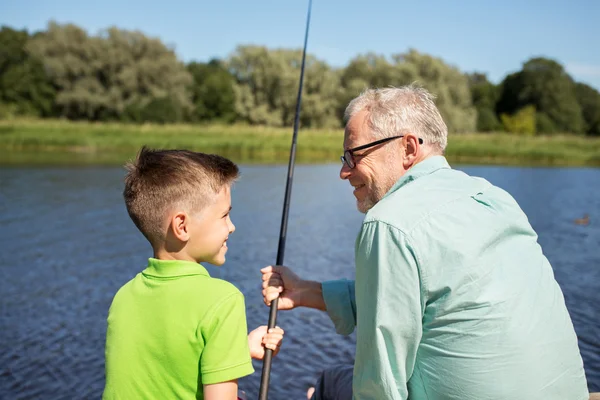 Grandfather and grandson fishing on river berth — Stock Photo, Image