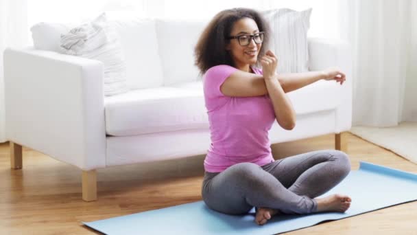 Femme africaine heureuse exerçant sur tapis à la maison — Video