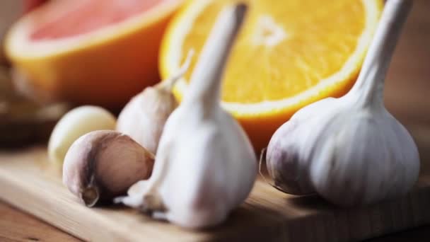 Ginger, grapefruit, orange and garlic on board — Stock video