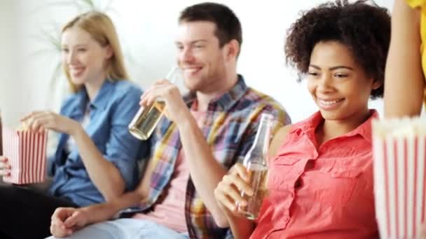 Amigos con palomitas de maíz y cerveza viendo la televisión en casa — Vídeos de Stock