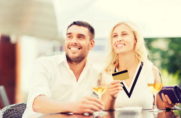 Šťastný pár s bankovní kartou a bill v restauraci — Stock fotografie