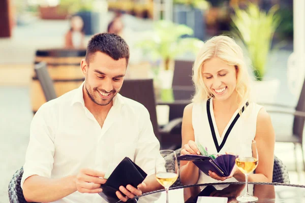 Feliz pareja con billetera pagando la factura en el restaurante — Foto de Stock