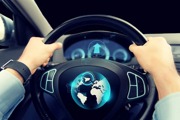 Bliska człowieka jazda samochodem z globe na ekranie — Zdjęcie stockowe
