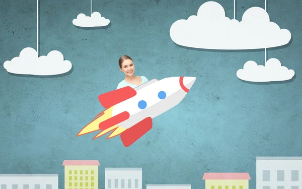 Tiener meisje vliegen op raket boven beeldverhaal stad — Stockfoto