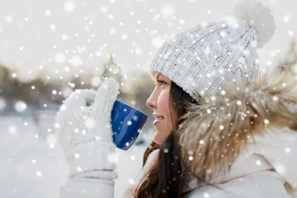 Heureuse jeune femme avec tasse de thé en plein air en hiver — Photo
