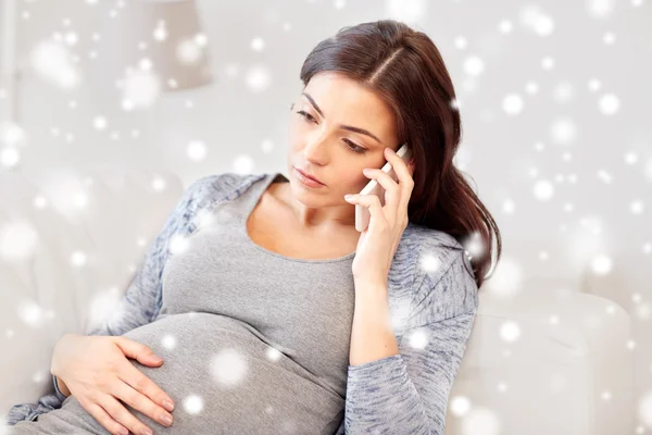 Mujer embarazada triste llamando en el teléfono inteligente en casa — Foto de Stock