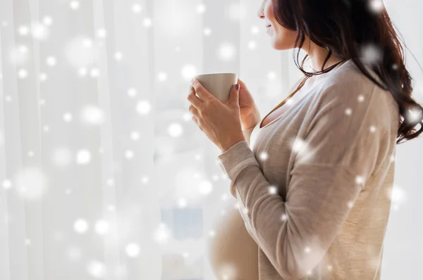 ウィンドウで紅茶のカップと妊娠中の女性のクローズ アップ — ストック写真