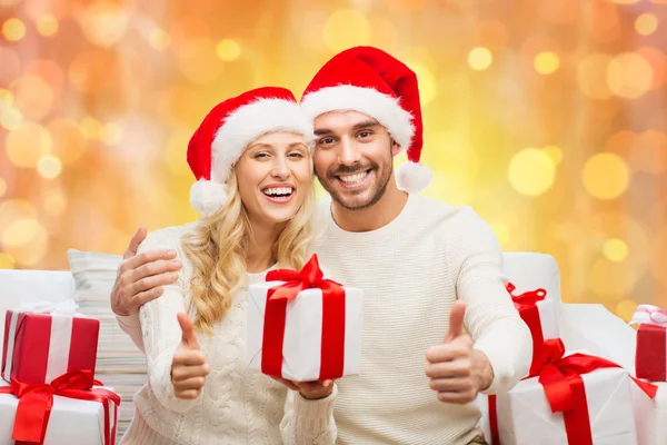 Casal feliz com presentes de Natal e polegares para cima — Fotografia de Stock